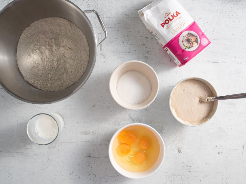 W misie mąka pzsenna. Obok w miseczkach składniki na ciasto drożdżowe.