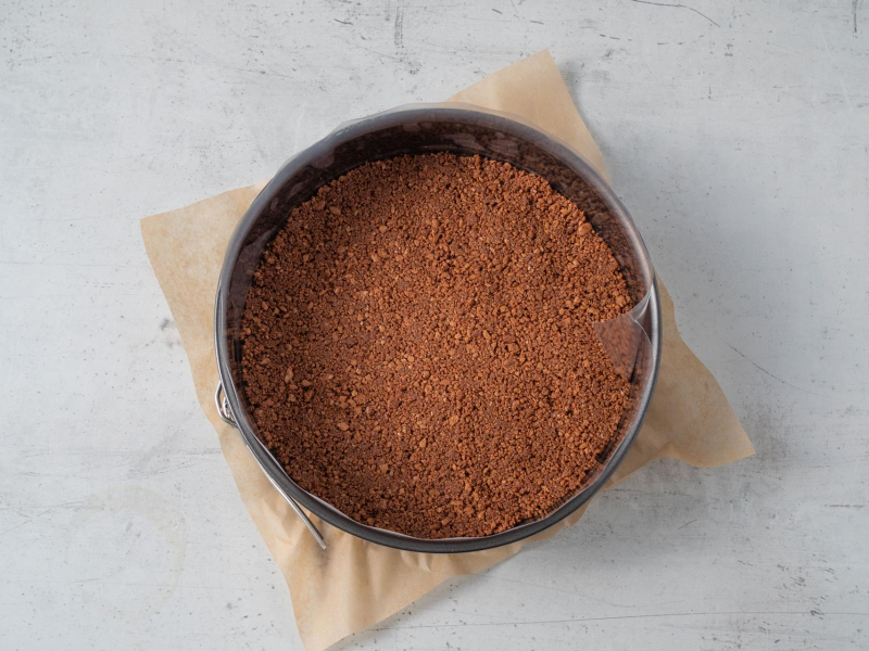 w tortownicy wyłożony spód ciasteczkowy z kakaowych ciasteczek