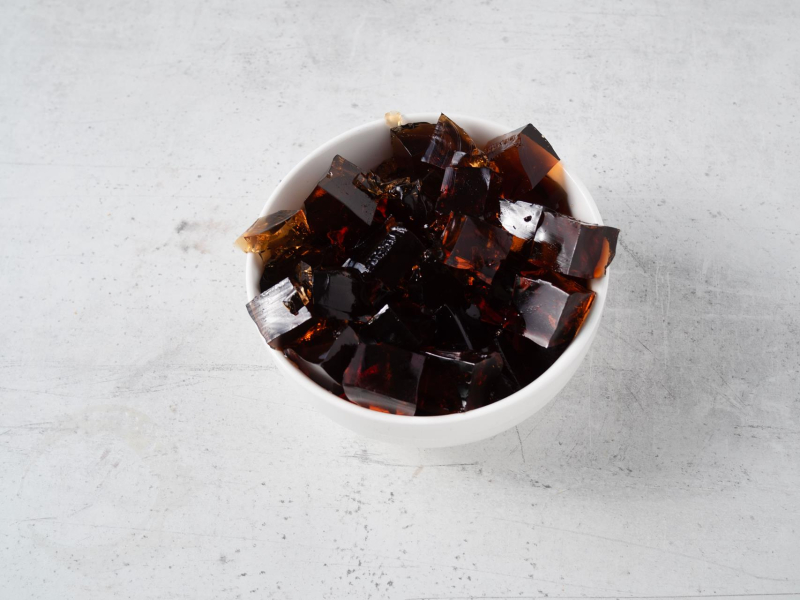 w miseczce pokrojona w kostkę galaretka o smaku coli