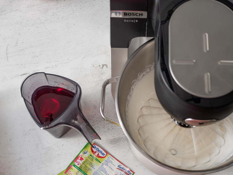 w robocie kuchennym ubijana śmietanka obok naczynie z rozpuszczonymi galaretkami