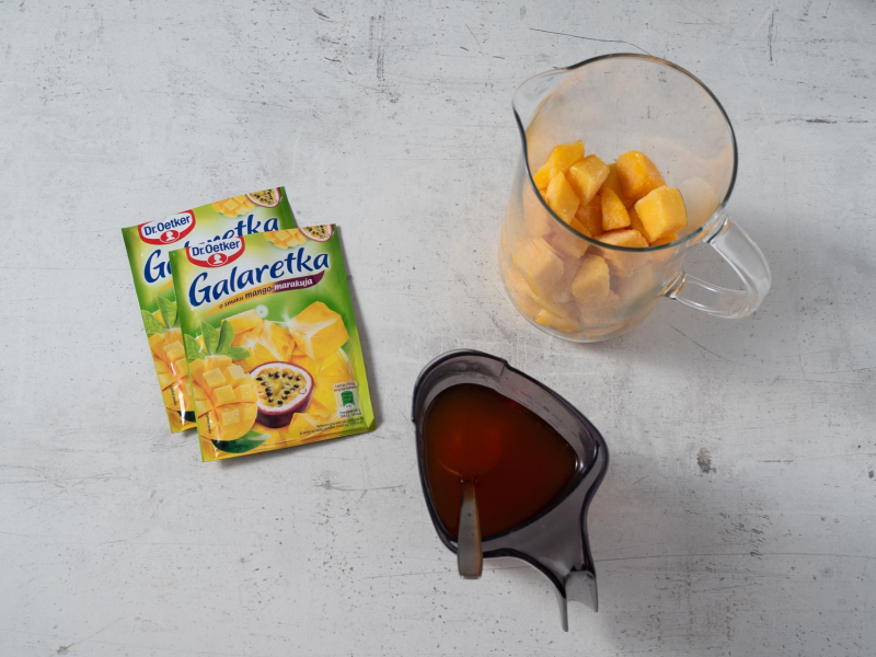 w szklanym naczyniu mango, w drugim rozpuszczone galaretki z mango marakuja