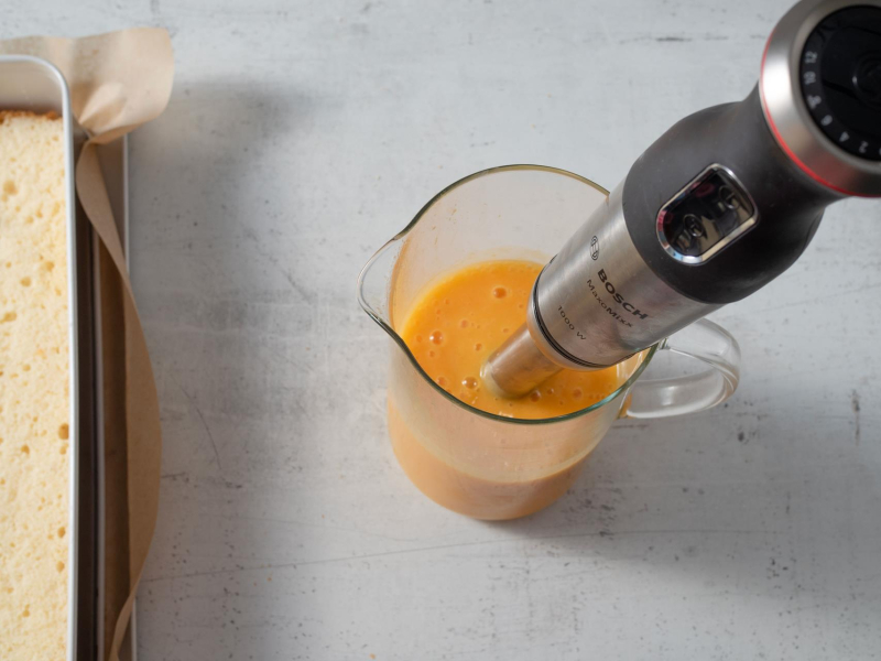 w szklanym naczyniu zblendowane mango z blenderem w środku