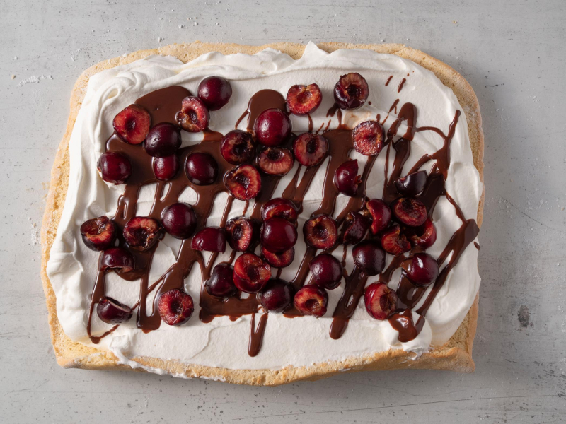 blat biszkoptu na roladę wyłożony kremem mascarpone, czereśniami iczekoladą