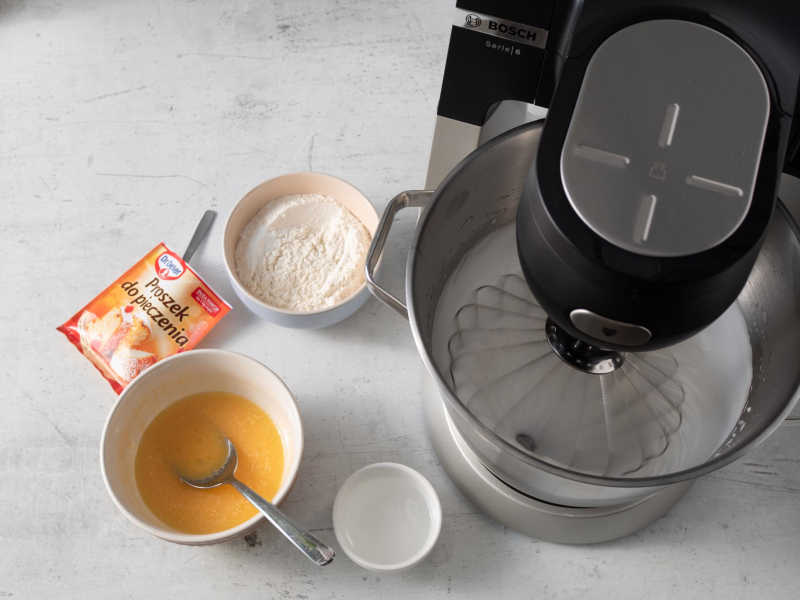 ubijane białka w robocie bosch, na blacie pozostałe składniki na roladę biszkoptową