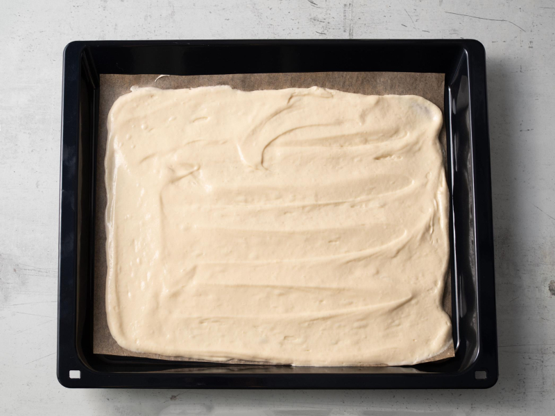 na formie z wyposażenia piekarnika wyłożone ciasto na biszkoptową roladę