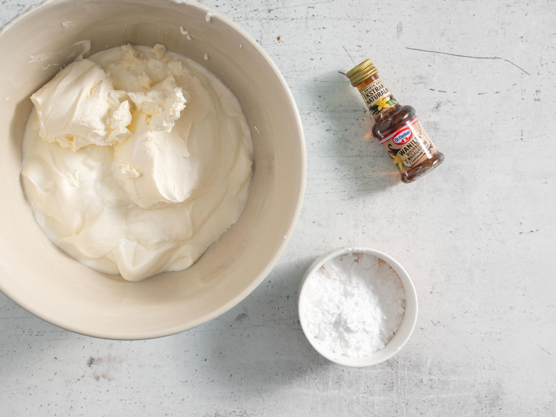 W misie jogurt ze śmietanką. Obok cukier puder i ekstrakt.