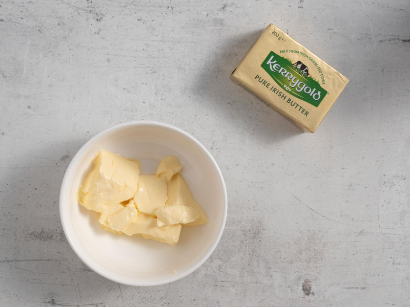 Na blacie kuchennym miska z miękkim masłem.
