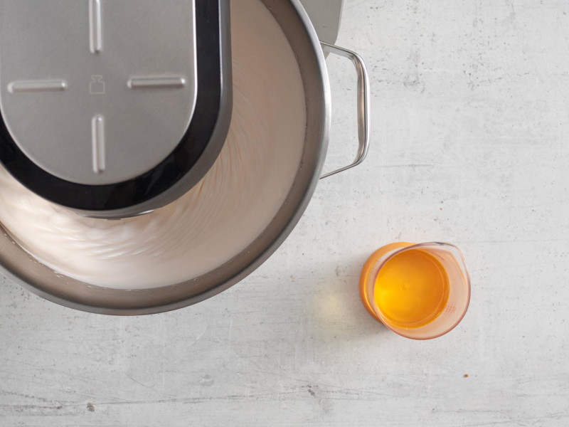 Ubijanie jajek z cukrem w robocie kuchennym. Obok olej rzepakowy.