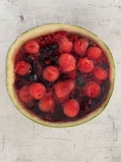 połówka arbuza wypełniona owocami i zalana krystaliczną galaretką