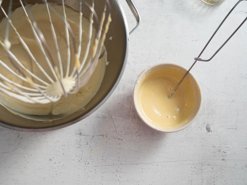 Rozmieszany pudding  z żelatyną w miseczce. Obok w misie ubita masa.