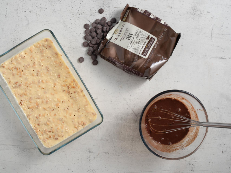 W naczyniu żaroodpornym wymieszana masa na proteinowe kinder country. Obok w opakowaniu czekolada.