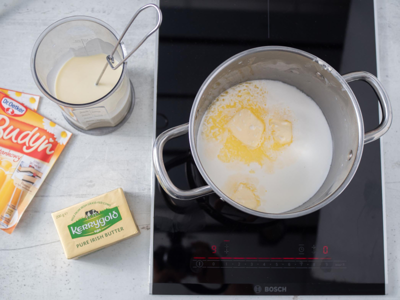 w garnku na płycie mleko z masłem