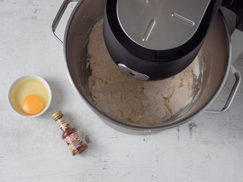 w misie robota mąka z masłem obok w miseczce jajko i ekstrakt waniliowy dr. oetkera