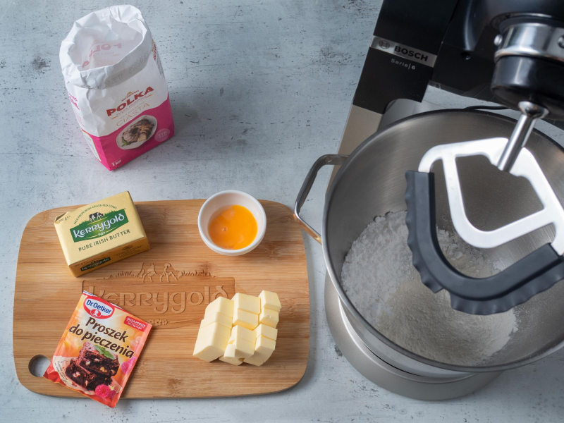 mąka polka, masło kerrygold i proszek do pieczenia Dr. Oetkera na desce obok robot bosch