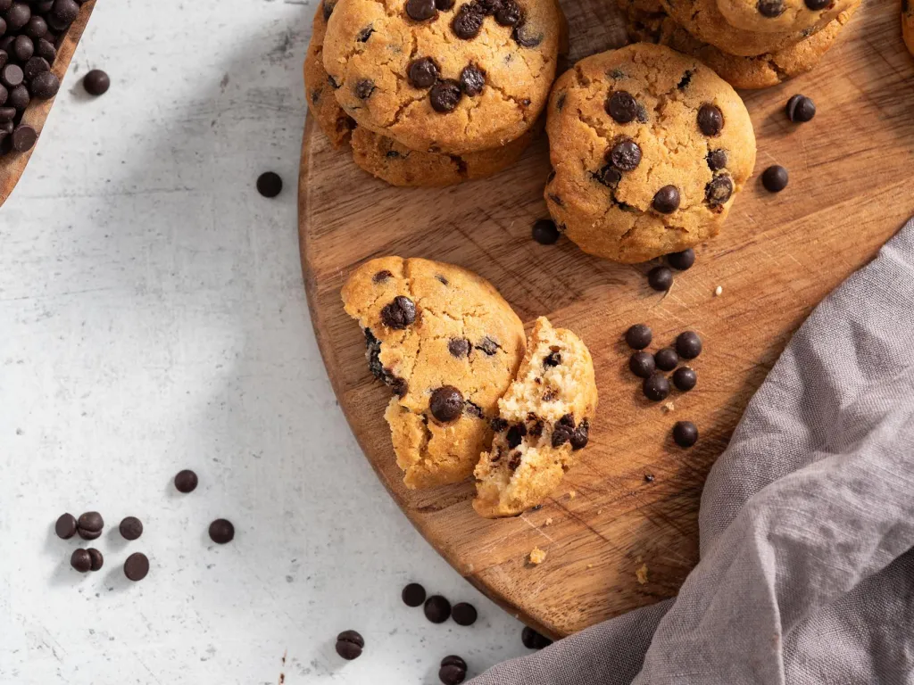 Ciasteczka z airfryer z kawałkami czekolady na drewnianej desce, ujęcie od góry - przepis Wszystkiego Słodkiego
