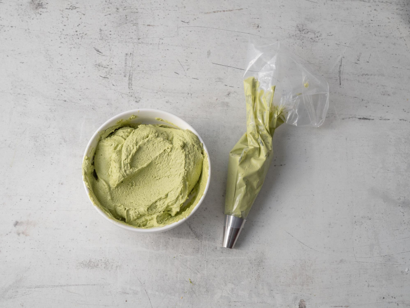 krem matcha w miseczce, obok krem w rękawie cukierniczym