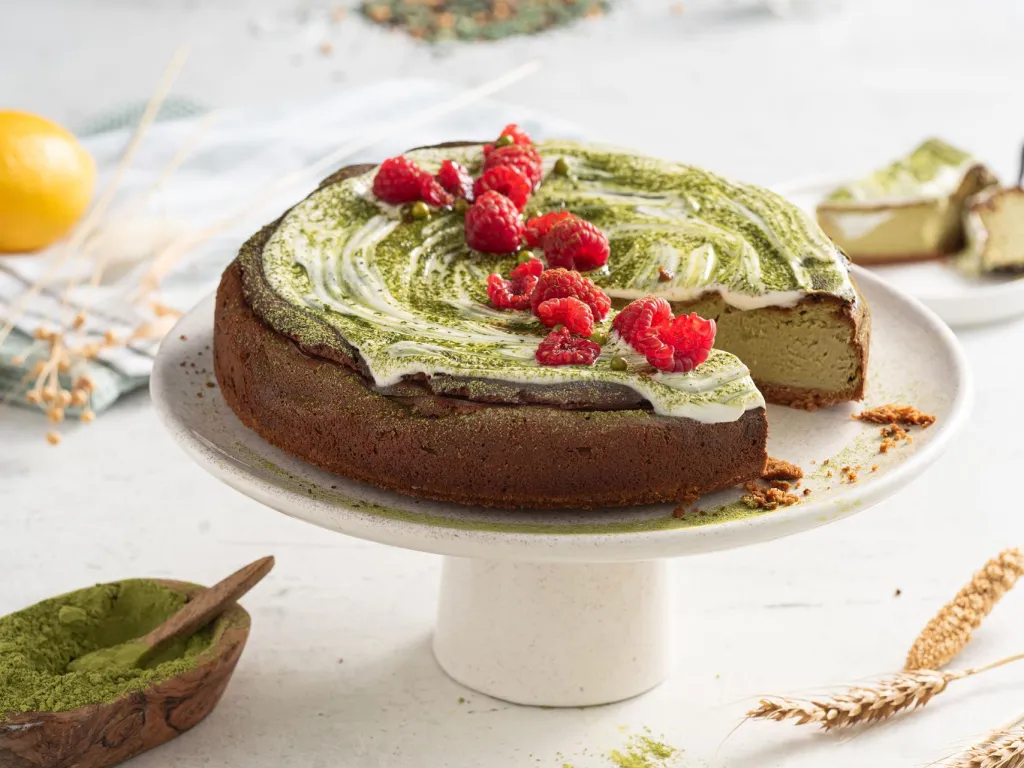 Pieczony sernik z matchą na białej paterze z malinami - przepis Wszystkiego Słodkiego