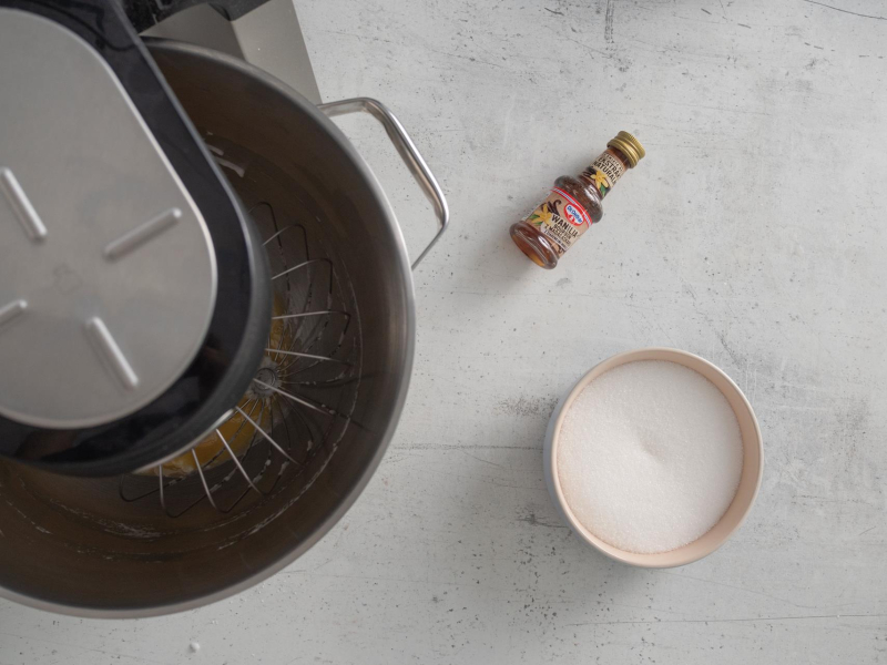 Na blacie kuchennym cukier oraz ekstrakt waniliowy.