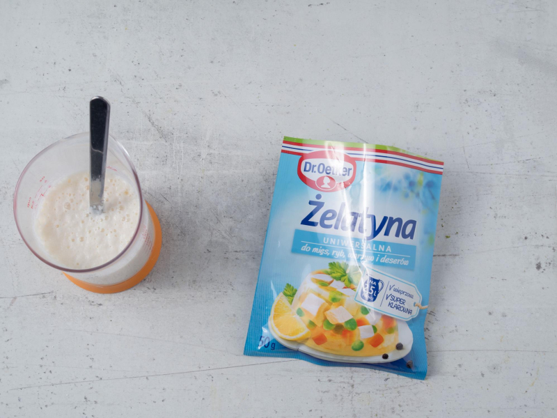 namoczona żelatyna  w mleku obok opakowanie żelatny Dr. Oetkera