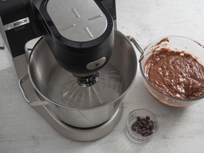 Ubijanie białek w robocie kuchennym. Obok wymieszane ciasto oraz czekoladowe kaletki.