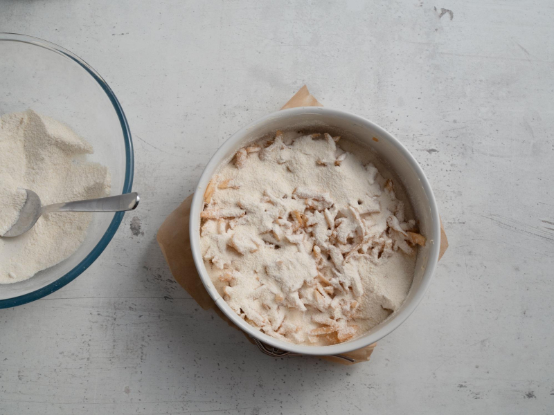 w tortownicy sypana szarlotka przed pieczeniem