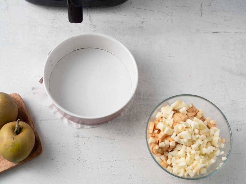 pokrojone w misce jabłka i tortownica do placka z jabłkami pieczonego w airfryer