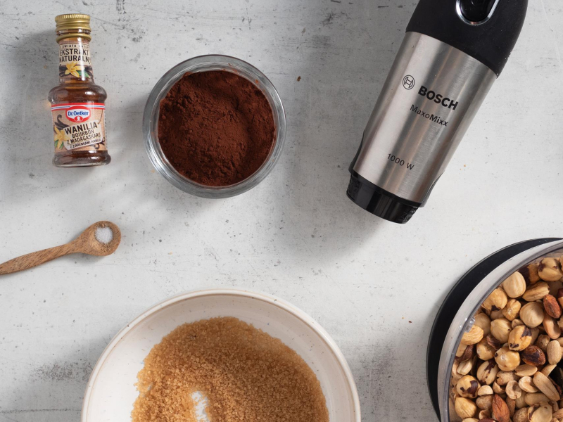 podprażone orzechy w misie malaksera. Obok ekstrakt waniliowy , cukier trzcinowy i ciemne kakao .