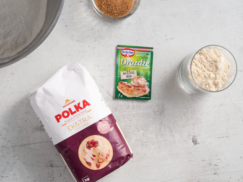 Na blacie kuchennym mąka pszenna, drożdże suszone oraz odżywka białkowa.