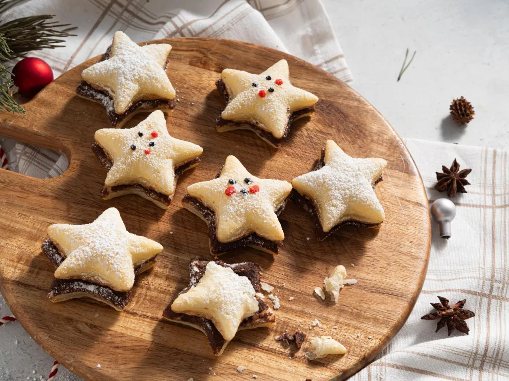 Francuskie ciasteczka z czekoladą oprószone cukrem pudrem na drewnianej paterze - przepis Wszystkiego Słodkiego