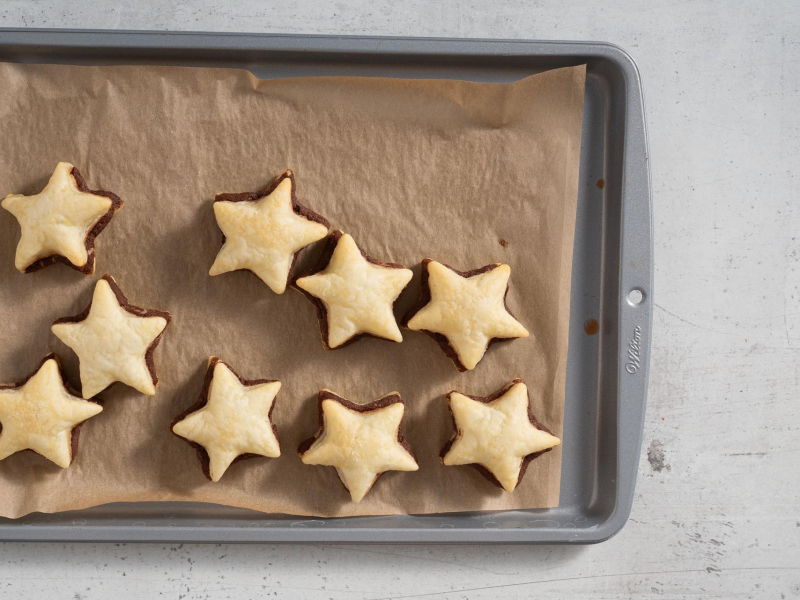Upieczone ciasteczka francuskie z kremem czekoladowym na blaszce do pieczenia.