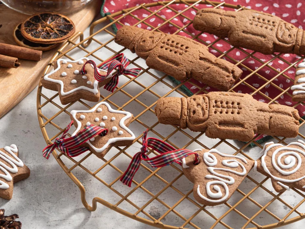 Zbliżenie na szybkie pierniczki w kształcie serduszek, gwiazdek i dziadka do orzechów na kratce - przepis Wszystkiego Słodkiego