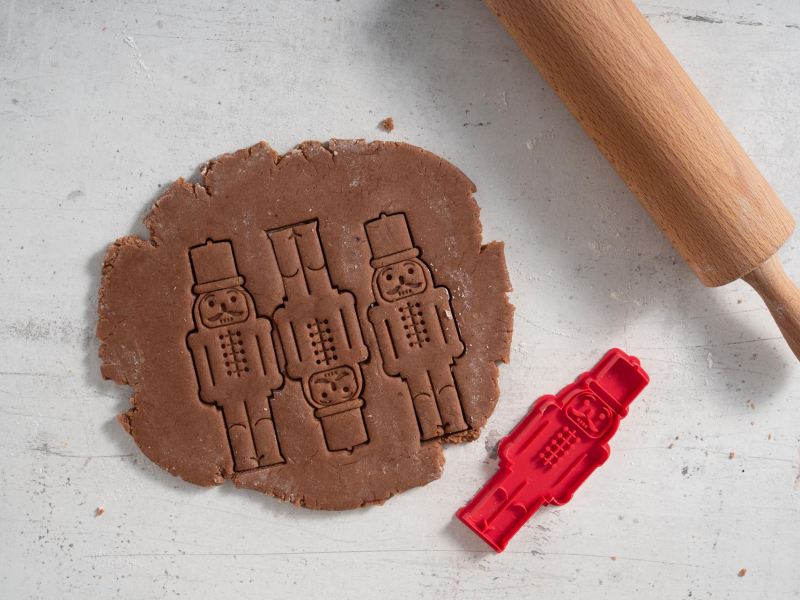 Wycinanie z ciasta pierniczków w kształcie dziadka do orzechów.