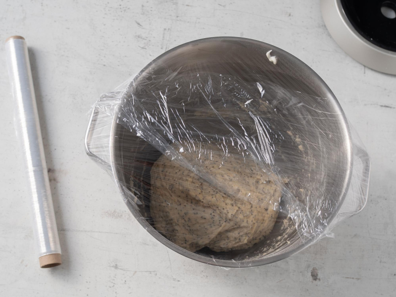 w metalowej misie ciasto drożdżowe z makiem owinięte folią spożywczą