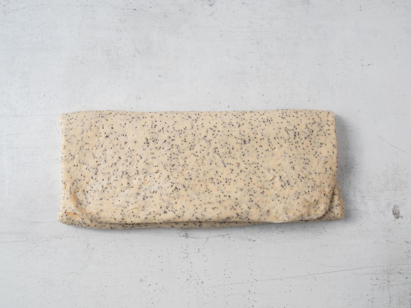 rozwałkowane i złożone na prostokąt ciasto drożdżowe na cynamonki