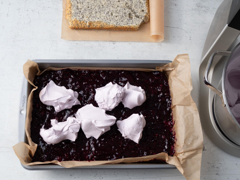 krem śmietankowy wyłożony porcjami na warstwie z porzeczek na cieście