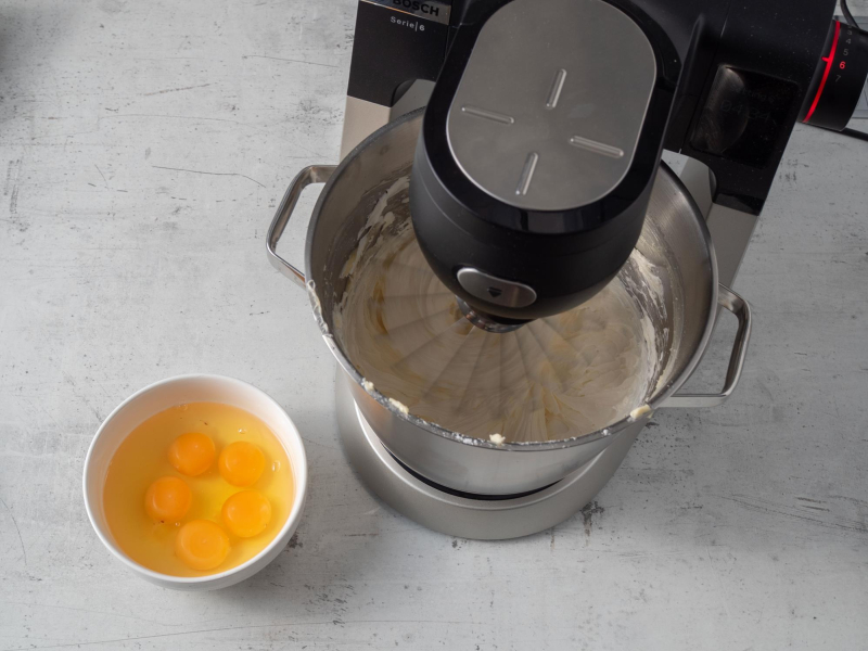 w robocie ubijane masło obok miseczka z jajkami