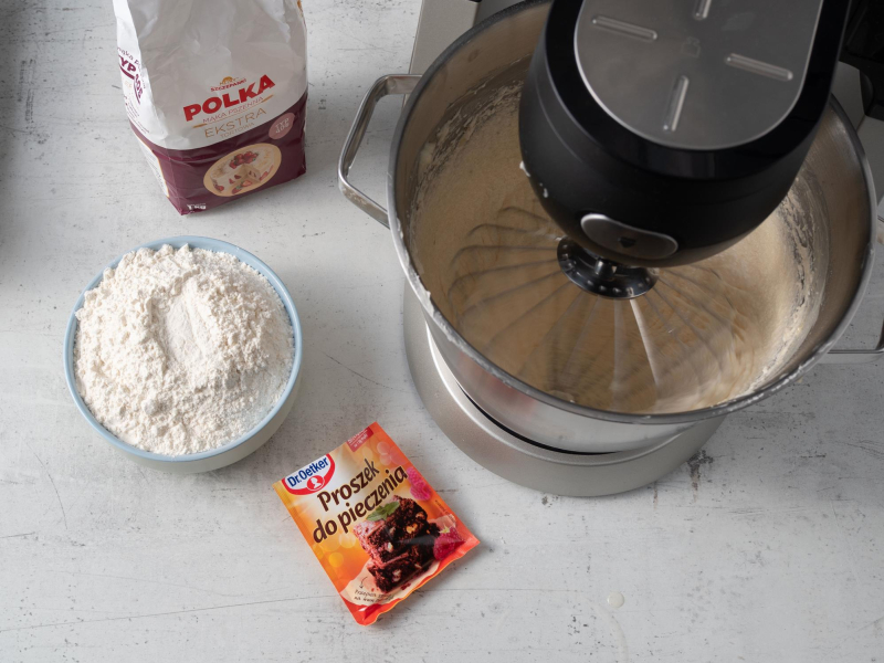 na blacie mąka polka i proszek do pieczenia Dr. Oetkera i robot z ubijanym ciastem