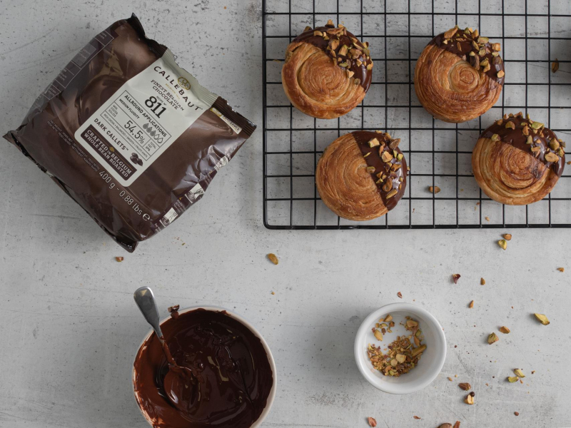 Na blacie kuchennym czekolada oraz gotowe rollsy.