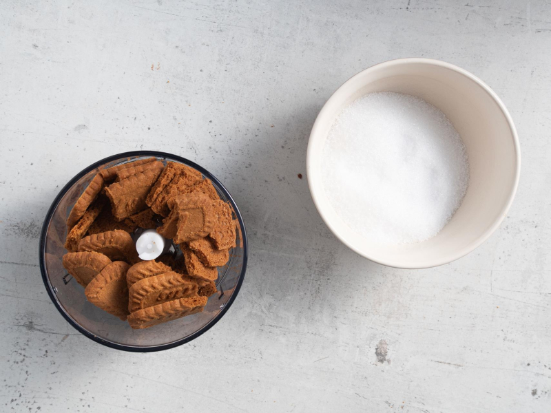 Ciasteczka korzenne w pojemniku do rozdrabniania. Obok słodzik w miseczce.