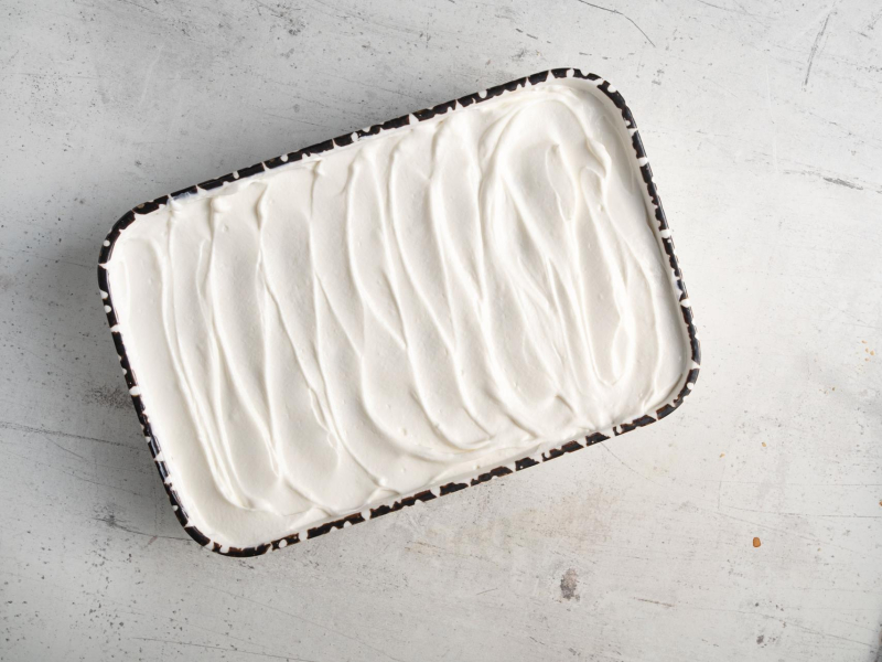 Masa do tiramisu proteinowego rozsmarowana na biszkoptach.