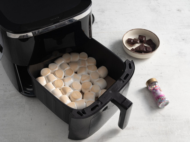 Zapiekane pianki marshmallow w airfryer. Obok czekolada oraz dekoracje cukrowe.