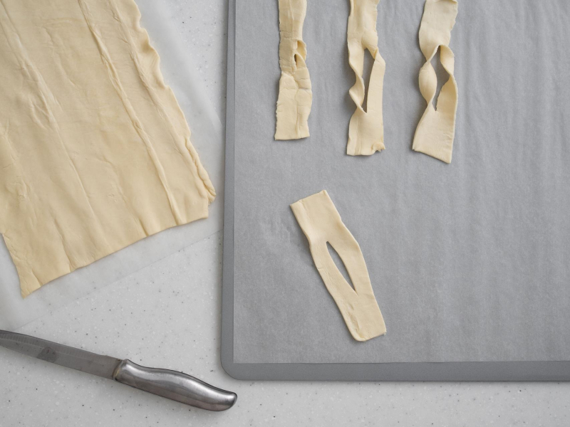 arkusz ciasta francuskiego pocięty na prostokąty z nacięciem po środku