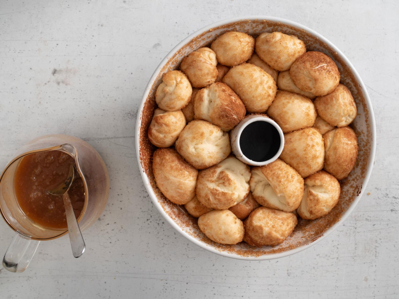 Wyrośnięte ciasto na małpki chlebek.  Obok sos karmelowy.