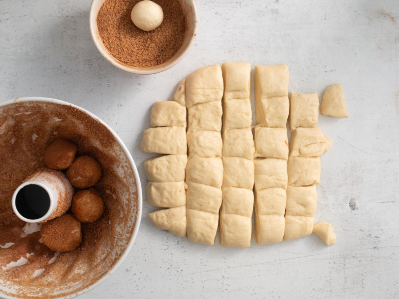 Układanie kawałków ciasta drożdżowego w formie.