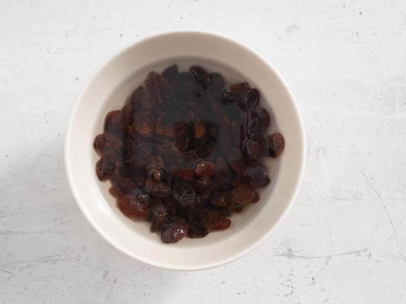 Rodzynki namoczone w rumie i wodzie w miseczce.
