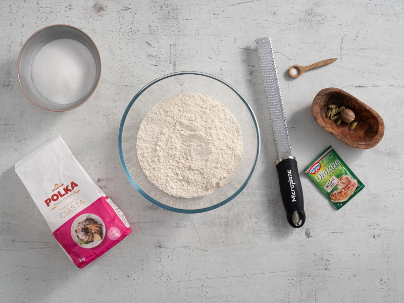 W misie mąka. Obok opakowanie mąki, drożdży, cukier oraz przyprawy.