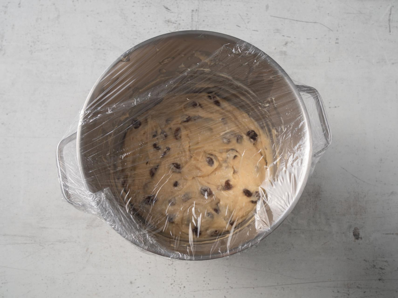 misa od robota z ciastem drożdżowym na babkę z rodzynkami przykryta folią spożywczą