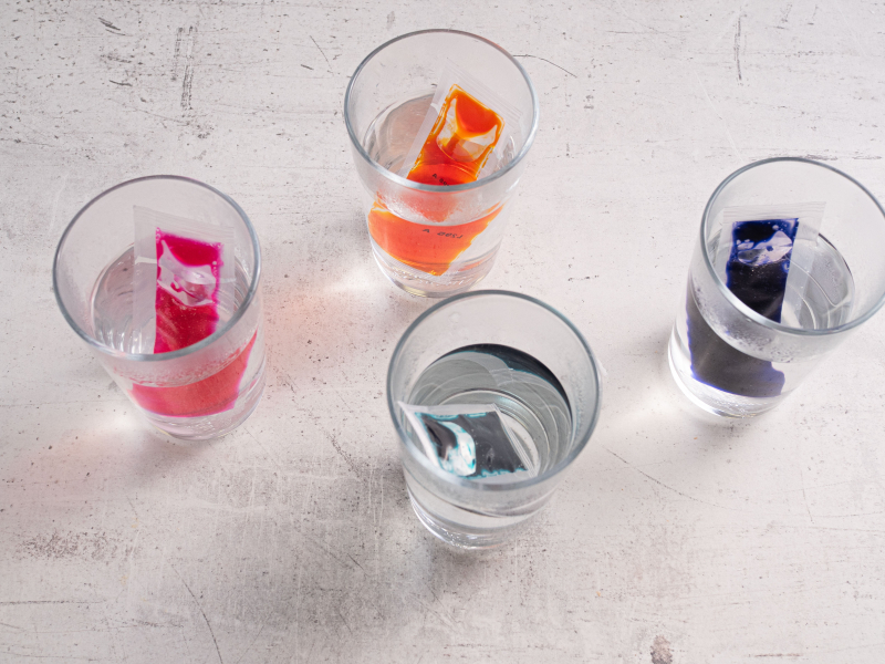 barwniki do jajek włożone do szklanek z gorącą wodą