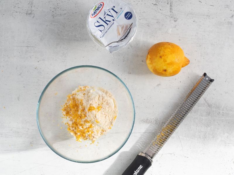 Na blacie kuchennym skyr naturalny oraz skórka z cytryny.