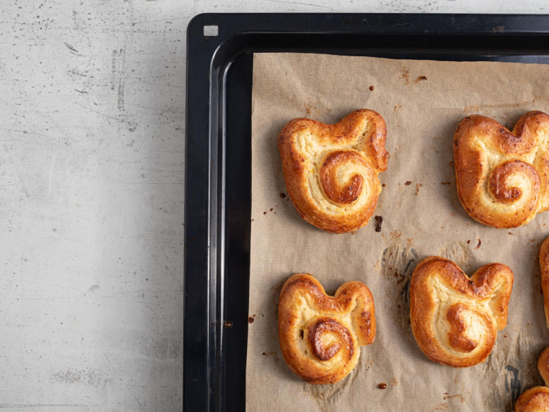 Upieczone drożdżowe króliczki na blasze do pieczenia.